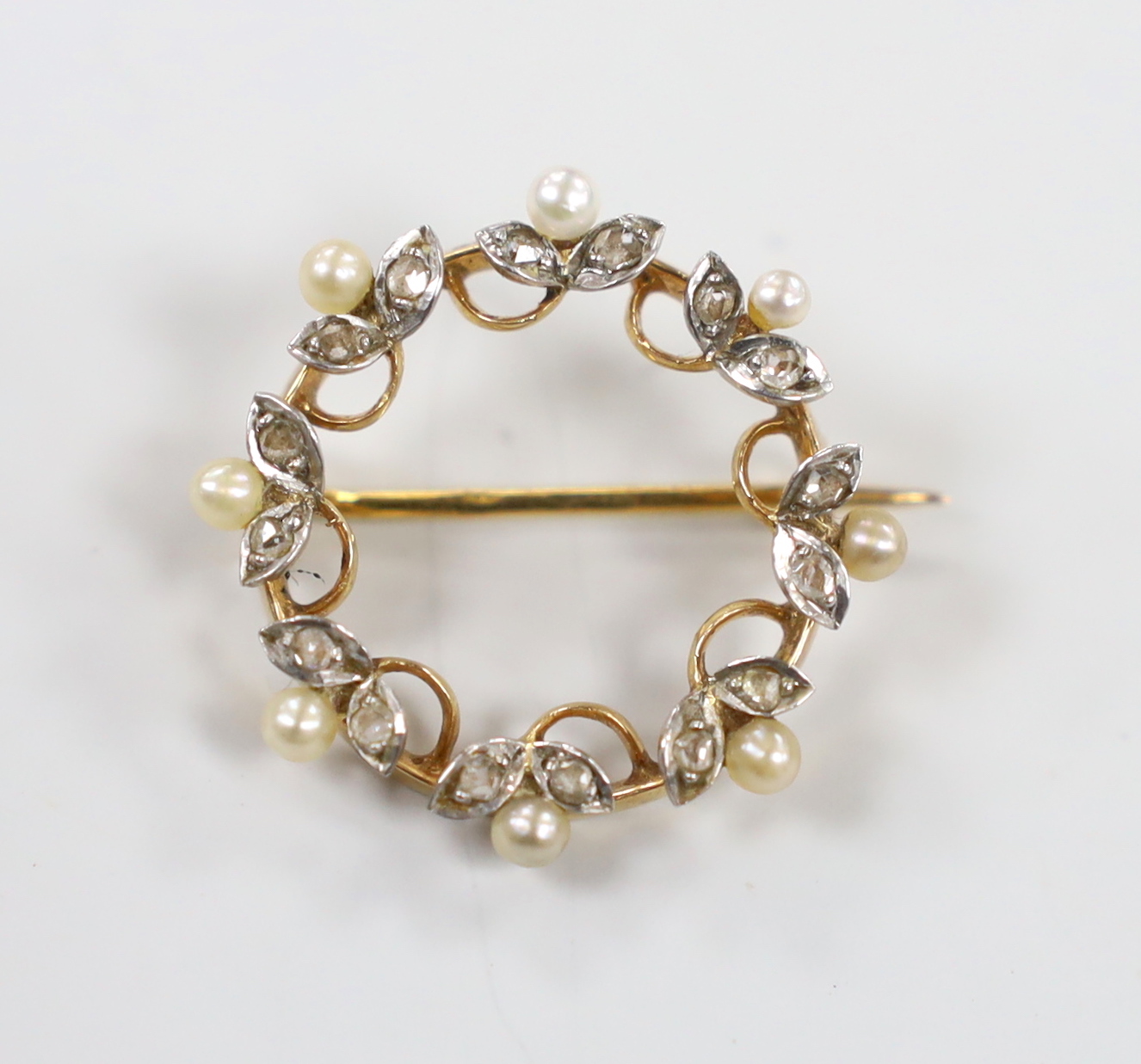 A late 19th century French yellow metal (18ct poincon mark), seed pearl and rose cut diamond set open work brooch, 23mm, gross weight 3.7 grams.